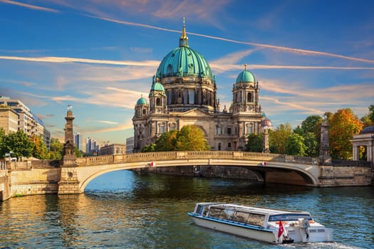 Cruise Ship is sailing near the Attractive cathedral or Berliner Dom on Museum Island, Berlin, Germany.