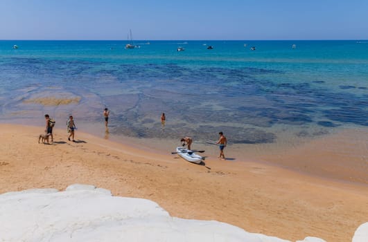 Sicily, Italy: August 9, 2024: Some people at the Beach of Scala dei Turchi (Stair of the Turks) in Sicily, Italy