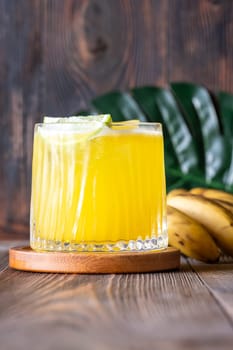 ropical cocktail with banana accents rustic wooden backdrop