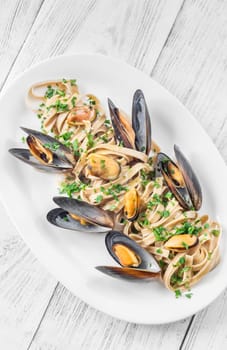 A plate of creamy fettuccine with fresh mussels