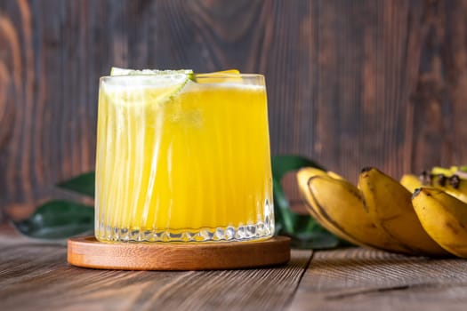 ropical cocktail with banana accents rustic wooden backdrop