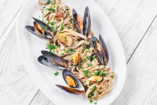 A plate of creamy fettuccine with fresh mussels