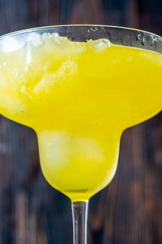 Frozen banana margarita cocktail on rustic wooden table