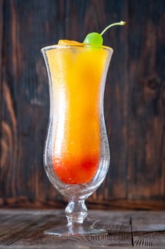 Banana Rum Punch cocktail garnished with green maraschino cherry