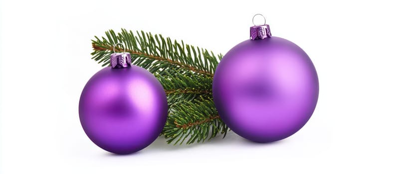 Two purple ornaments sit on a pine branch capturing the essence of Christmas decor and holiday spirit.