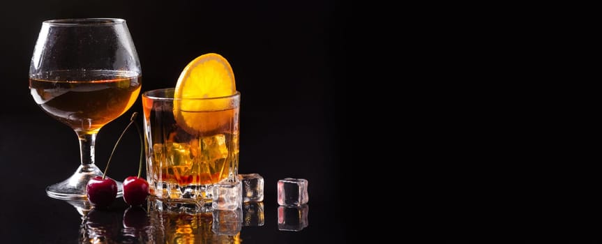 front view whiskey with orange cognac glass with copy space