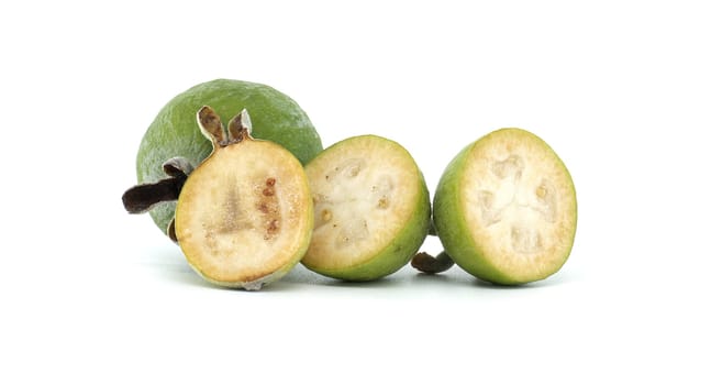 A close-up image of fresh, green feijoa fruits, including both whole and sliced, showcasing their texture and vibrant color against a clean white background, emphasizing natural health and freshness.