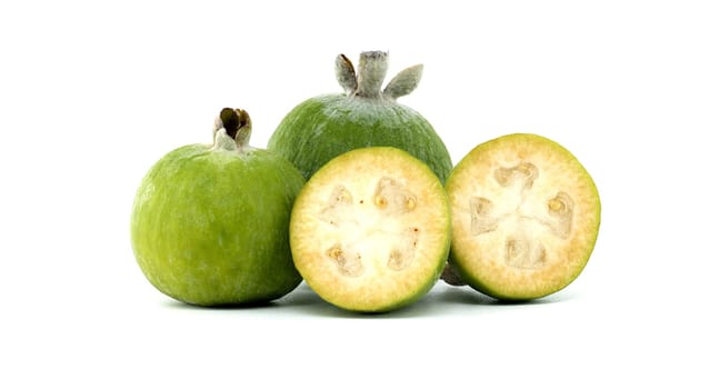 A group of fresh green feijoa fruits with two halves displayed on a white background, highlighting their juicy interior and vibrant color. Perfect for health, nutrition, and tropical fruit concepts.
