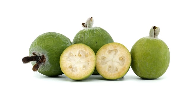 A close-up image of fresh, green feijoa fruits, including both whole and sliced, showcasing their texture and vibrant color against a clean white background, emphasizing natural health and freshness.