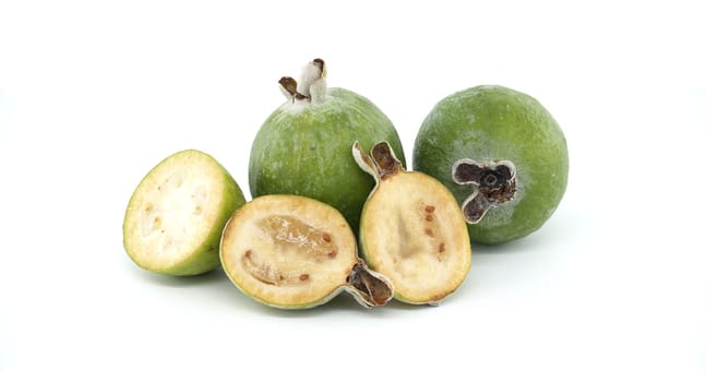Vibrant green feijoa fruits displayed with sliced halves, revealing juicy interiors. Perfect for concepts of freshness, organic produce, and healthy eating. Set against a clean white background