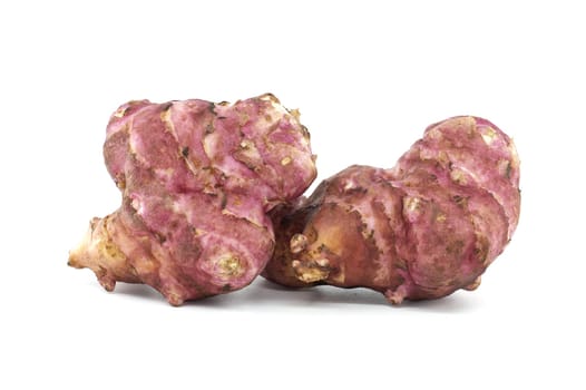 Detailed image of two fresh pink Jerusalem artichokes against a white background. Perfect for culinary, botanical, and healthy eating concepts. Highlights texture and natural color of these unique tubers