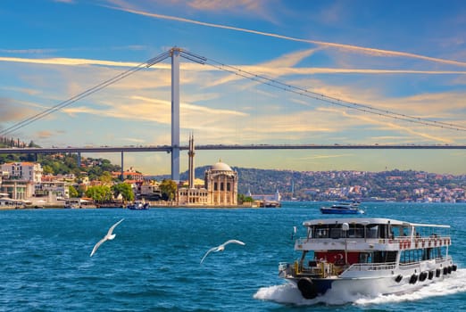 The cruise boat on the Bosphorus near the Grand Imperial  Ortakoy Mosque, Istanbul, Turkey.