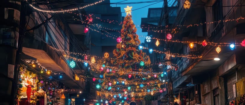 Colorful lights and decorations fill a narrow street featuring a tall Christmas tree and festive ornaments as evening falls.