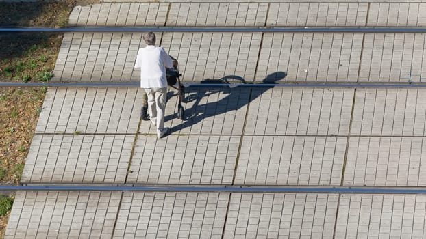 Old woman of retirement age dangerously crossing streetcar tracks in the city center of Magdeburg, Germany. Free text space below