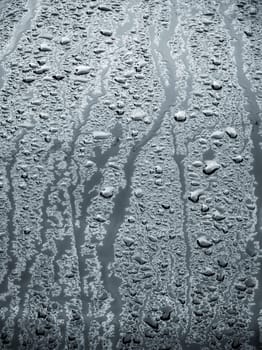 rain water drops on a bonnet of a black car during rainy day, full-frame closeup view