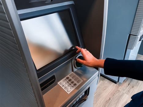 Woman withdrawing cash at ATM. Withdraw from bank account using debit card. Secure banking cash machine. Withdraw cash from cash dispenser. Financial transaction concept. Getting the cash at machine in bank branch