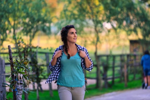 Young female farmer happily walks through her sunny farm, enjoying the outdoors and nature. She radiates a healthy, active lifestyle