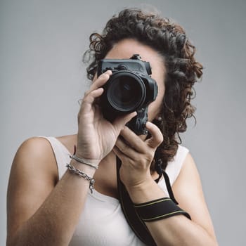 Photography instructor taking photos with professional camera, passing on knowledge to others during a photography class, sharing her expertise and passion for photography