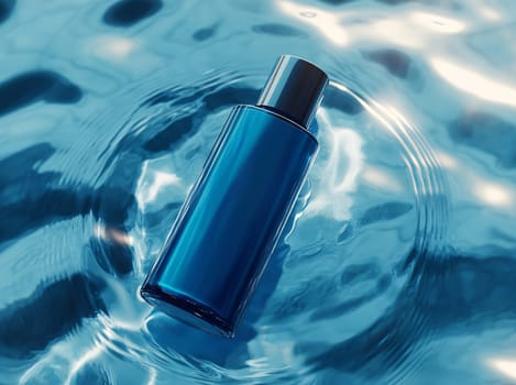 A sleek blue bottle gently floats on the surface of shimmering clear water, reflecting light. The scene conveys tranquility and freshness.