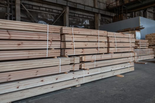 Stacked wooden planks close-up at lumber warehouse. Wood industry concept