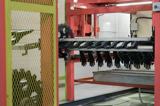 Close-up of a manufacturing machine producing gloves in an industrial factory, showcasing automation and production processes.
