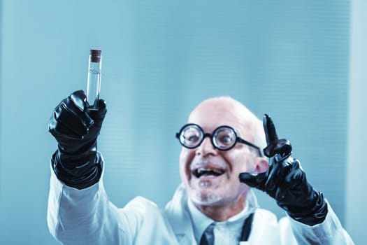 Scientist wearing black gloves and a lab coat holds up a test tube filled with a clear liquid, radiating excitement about a groundbreaking discovery in the laboratory