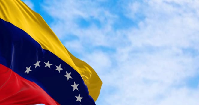 Close-up of Venezuela national flag waving on a clear day. Tricolor of yellow, blue and red with an arc of eight white five-pointed stars in the center. 3d illustration render. Selective focus