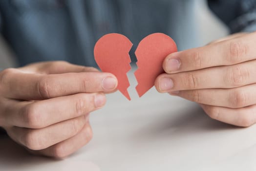 close up hands holding broken heart