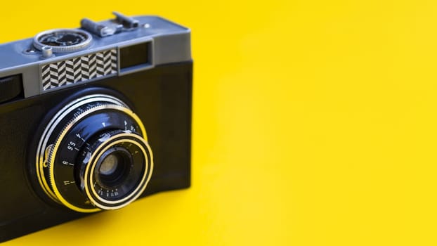 close up vintage photo camera with yellow background