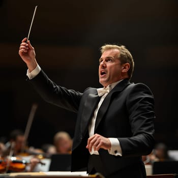 A dynamic conductor passionately directs an orchestra during a concert, exuding energy and precision.