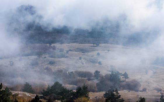 Low clouds over the valley, view from the mountains. Low clouds.