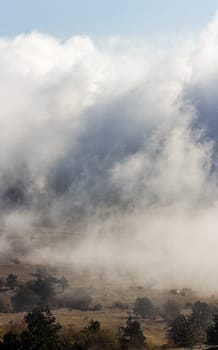 Low clouds over the valley, view from the mountains. Low clouds.