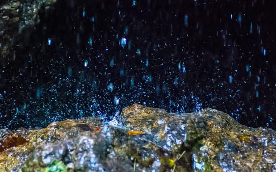Water flows through the rocks in the cave. A small waterfall at the entrance to the cave.