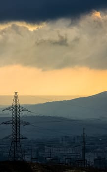 Dawn in the mountains of Crimea. A light haze of mist over the mountains and rays of the sun through the clouds.