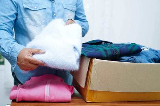 Clothes donations in cardboard box for volunteer.