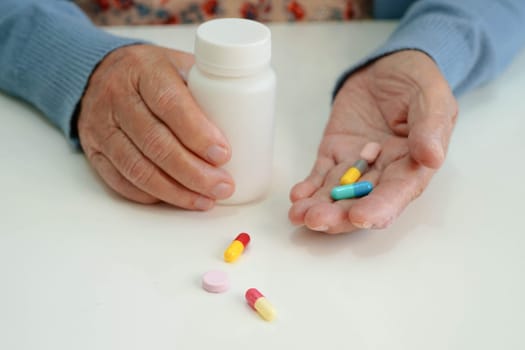 Asian elderly woman holding pill drug in hand, strong healthy medical.