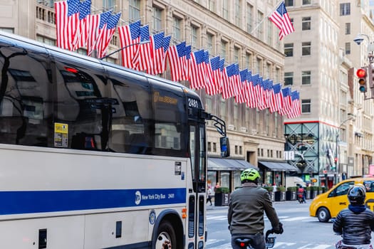 Manhattan, New York, USA - February 15, 2023: Typical bus driving in the city center on a sunny winter day