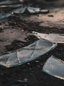 Scattered broken glass sharp edges pieces on the ground