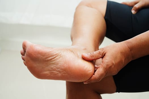 Asian woman check feet with crack and dry heel skin, Diabetic Foot.