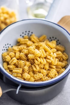 Uncooked italian pasta. Radiatori pasta in a colander.