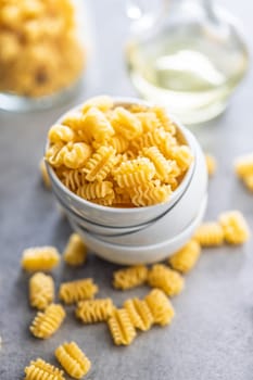 Uncooked italian pasta. Radiatori pasta in bowl on a kitchen table.