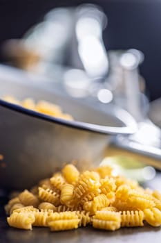 Uncooked italian pasta. Radiatori pasta on a black table.