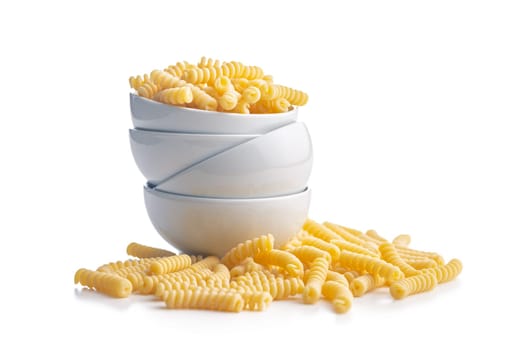 Uncooked italian pasta. Fusilli pasta in bowl isolated on a white background.