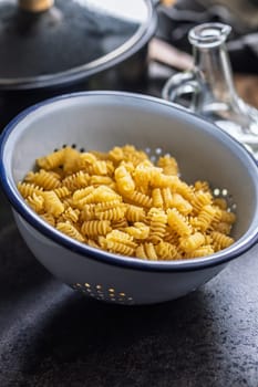 Uncooked italian pasta. Radiatori pasta in a colander.