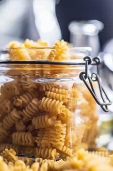 Uncooked italian pasta. Radiatori pasta in a jar.