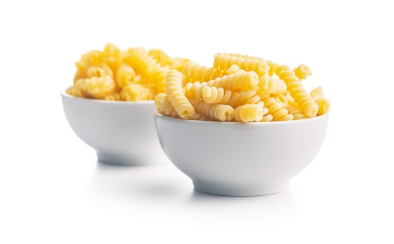 Uncooked italian pasta. Fusilli pasta in bowl isolated on a white background.