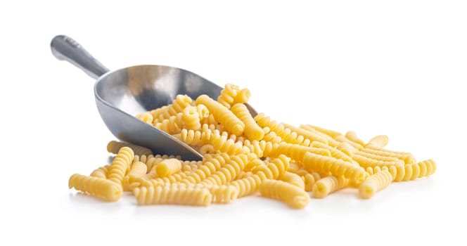 Uncooked italian pasta. Fusilli pasta in scoop isolated on a white background.