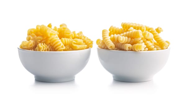 Uncooked italian pasta. Fusilli pasta in bowl isolated on a white background.