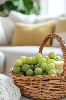 A wicker basket filled with ripe green grapes sits in a cozy living room with soft furnishings and warm decor.