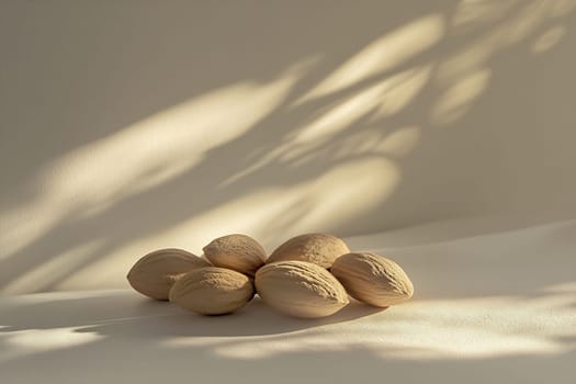 A collection of almonds is displayed on a light surface, with soft shadows playing around them, creating a serene atmosphere.